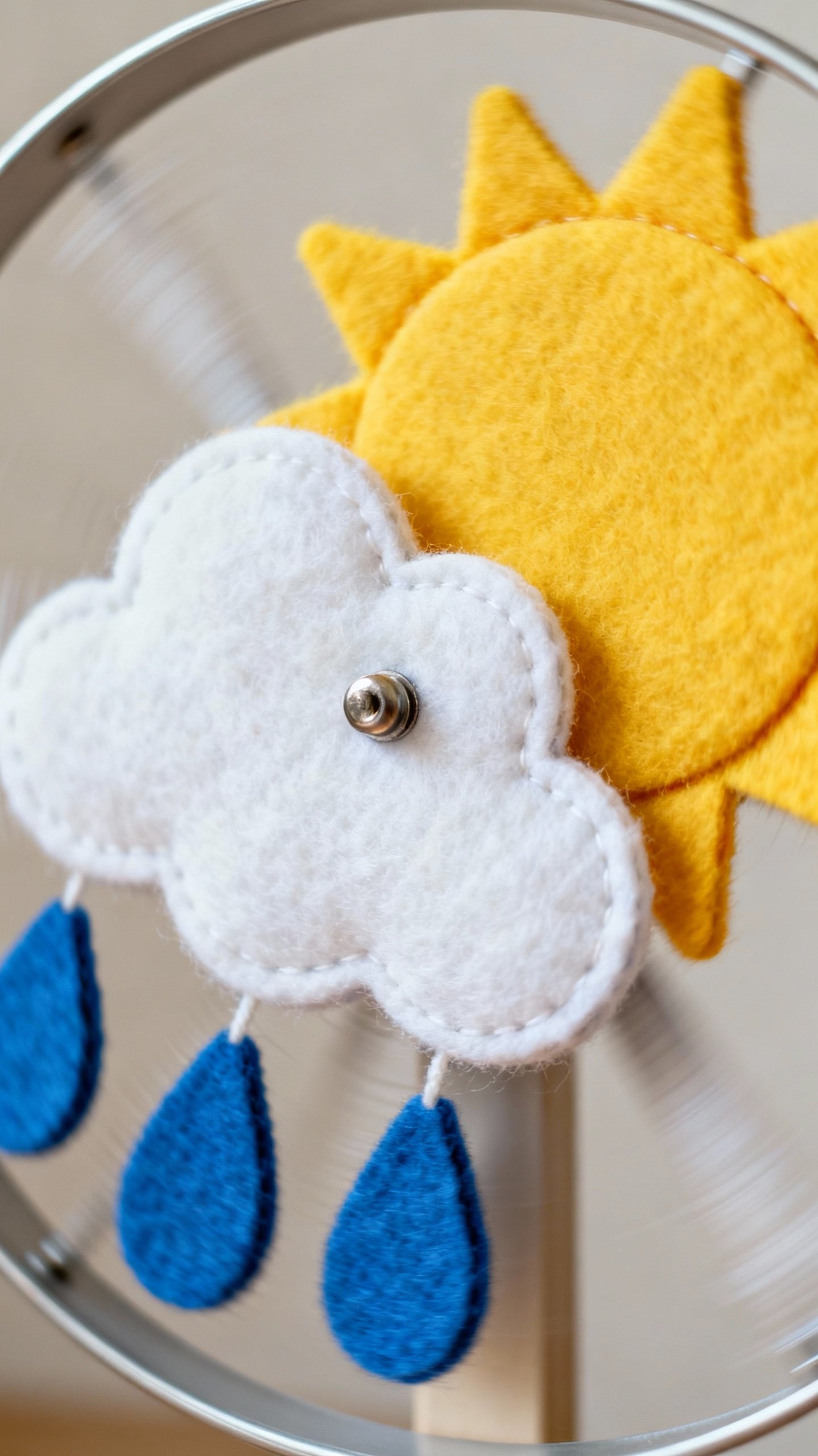 Closeup spinning weather wheel with felt sun, cloud, raindrops, brad center